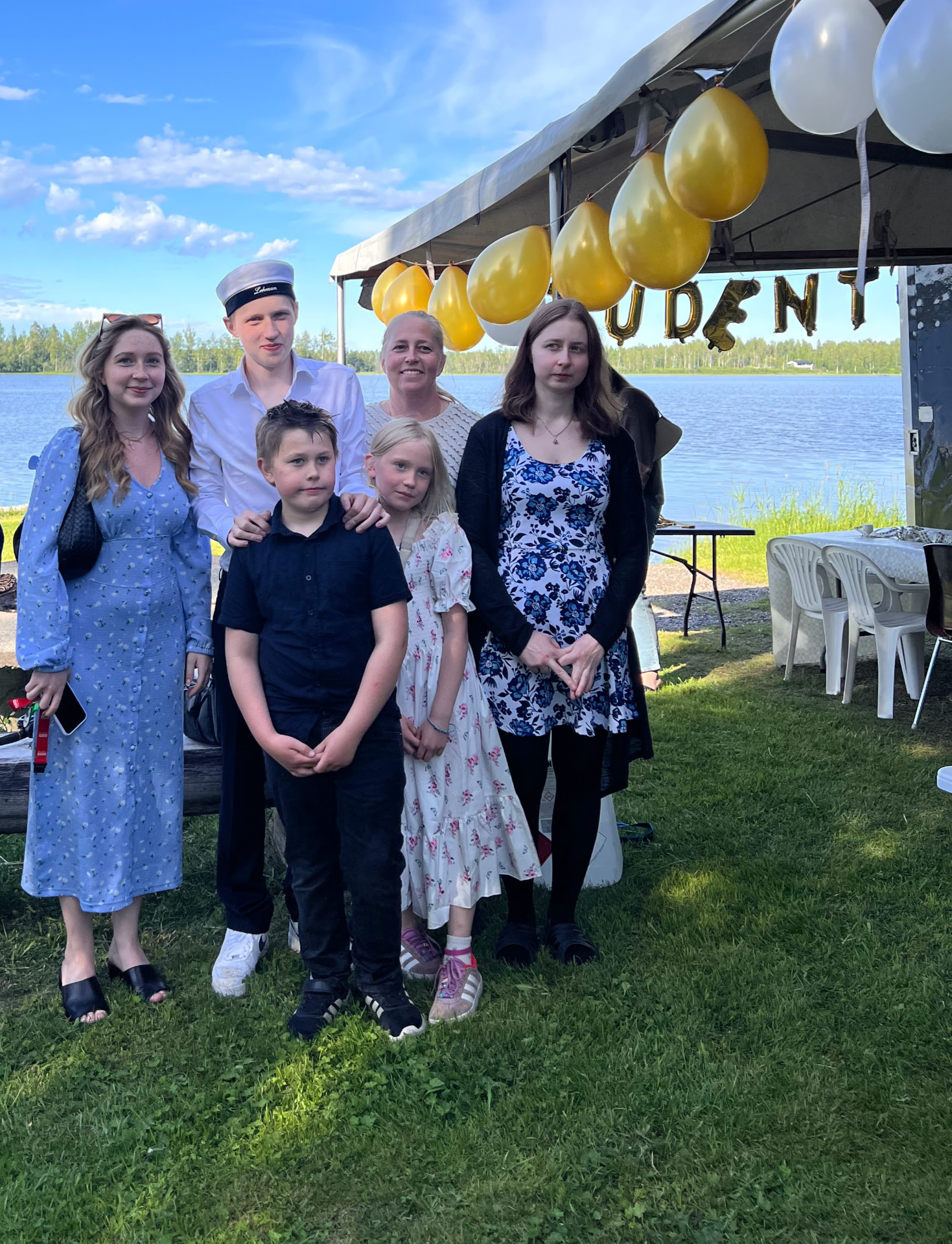 Nathan i studentmössa tillsammans med sina syskon och sin mamma vid sjön