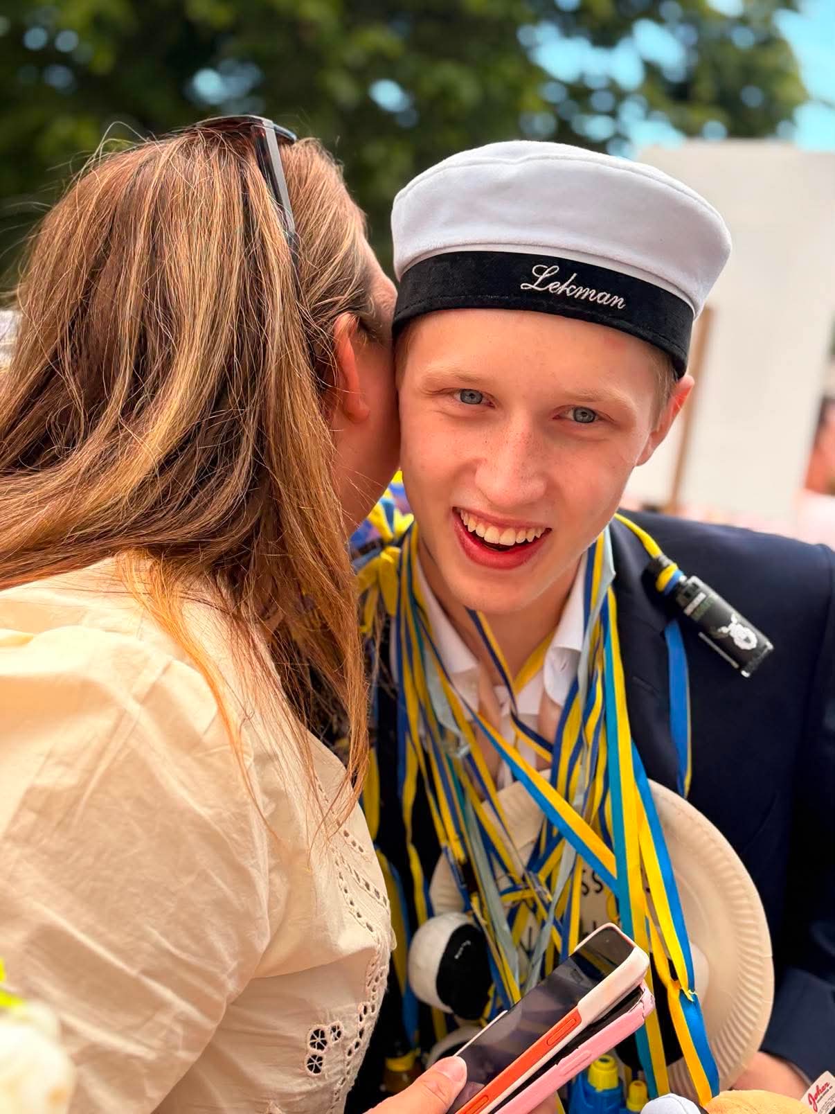 Nathan i studentmössa får en kram av sin mamma